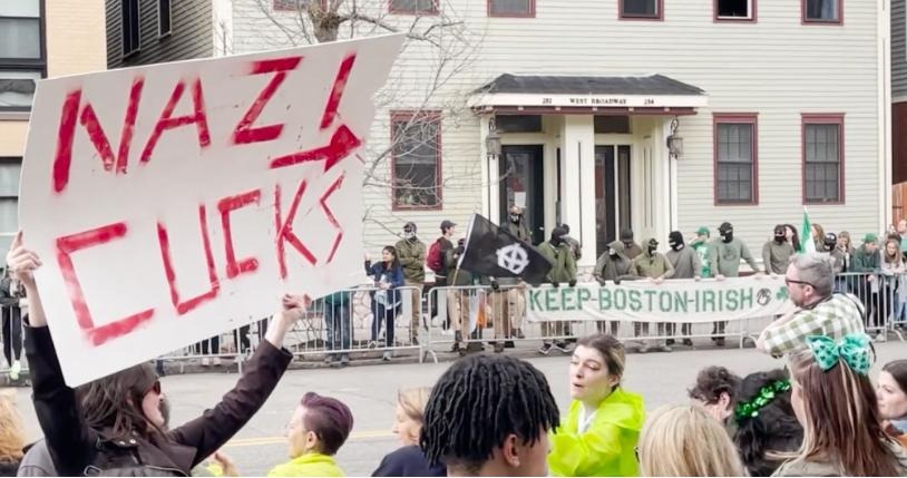 Woman holds sign that reads NAZI CUCKS in front of Nazis with a sign reading 'Kepp Boston Irish'